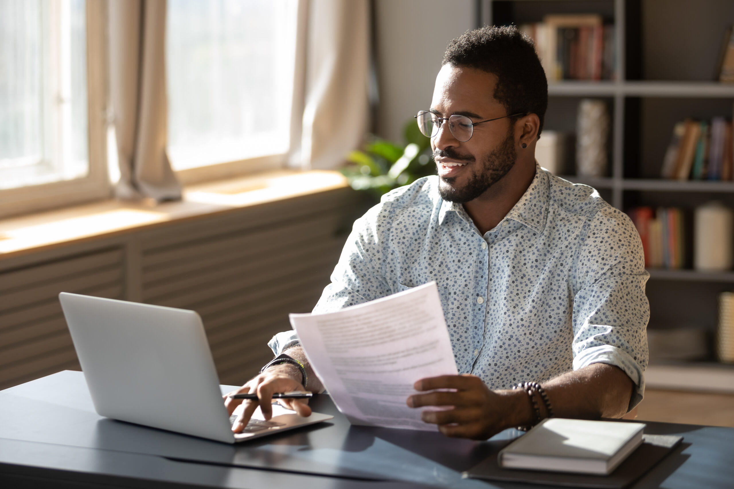 Happy,Millennial,African,American,Businessman,In,Eyewear,Holding,Documents,,Doing